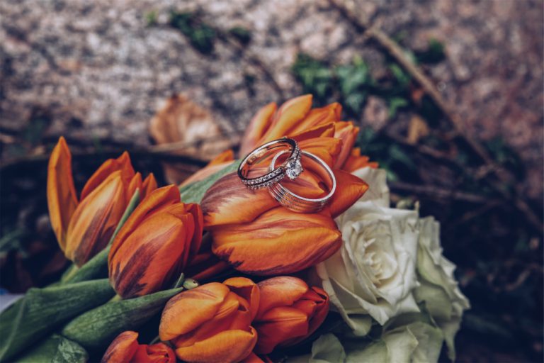 selective-closeup-shot-silver-diamond-rings-orange-tulips-white-roses